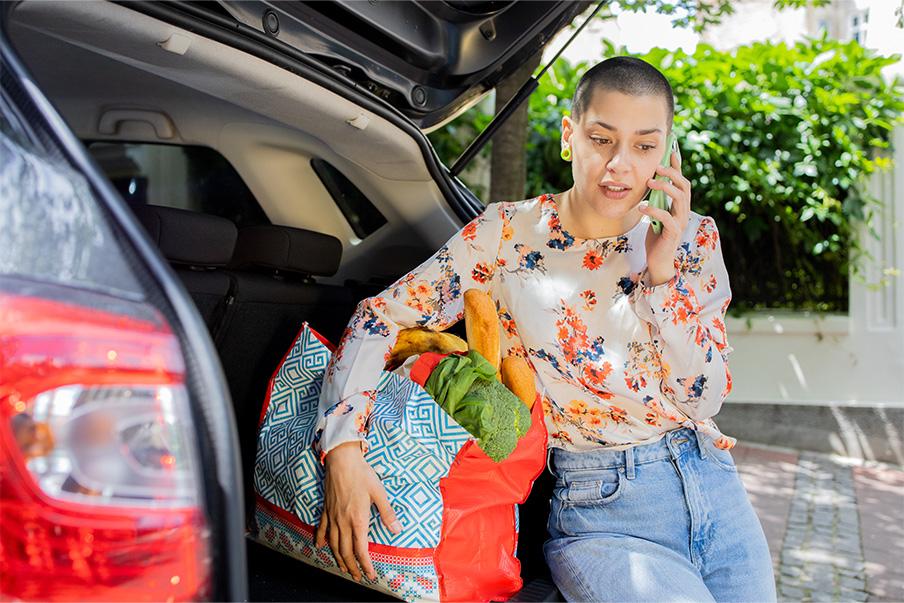 Woman on phone with car trunk open